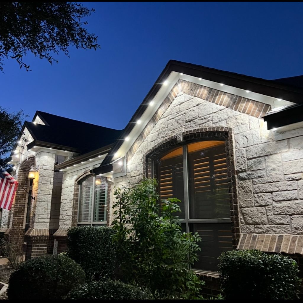 Warm white permanent LED lighting on a stone gable home