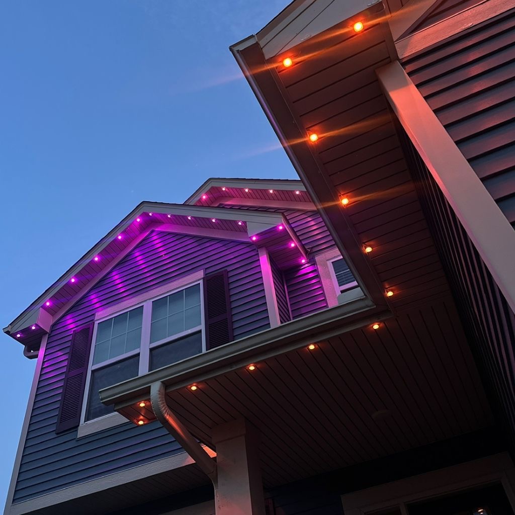 Purple and orange LED lighting on gables and soffit up close